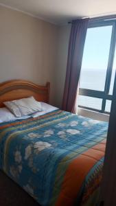 a bedroom with a bed with a colorful blanket and a window at don federico tome in Tomé