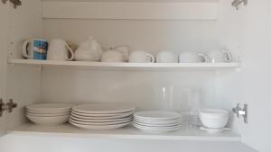 a shelf with plates and cups and bowls on it at don federico tome in Tomé