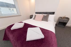 a bedroom with a large bed with two towels on it at Hampton House in Stockton-on-Tees