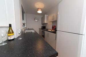 a kitchen with a white refrigerator and two wine glasses at Hampton House in Stockton-on-Tees +6 photos