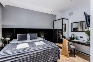 a bedroom with a large bed and a desk at Deo Plaza by Rent like home - Old Town in Gdańsk