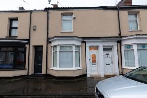 a house with white doors and a car parked in front at Hampton House in Stockton-on-Tees