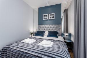 a bedroom with a large bed with blue walls at Deo Plaza by Rent like home - Old Town in Gdańsk