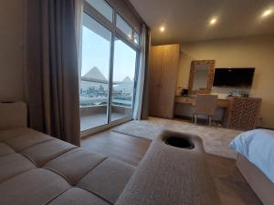 1 dormitorio con cama y ventana grande en DouDou Pyramids View Hotel en El Cairo