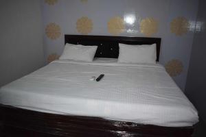 a bed with a cell phone sitting on top of it at OYO As Hotel And Restaurant Unit 2 in Meerut