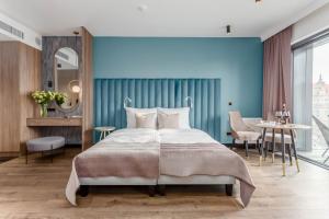 a bedroom with a bed and a blue wall at Deo Plaza by Rent like home - Old Town in Gdańsk