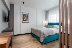 a bedroom with a blue bed and a window at Deo Plaza by Rent like home - Old Town in Gdańsk