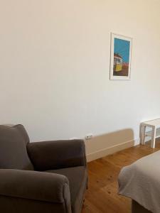 ein Wohnzimmer mit einem Sofa und einem Bild an der Wand in der Unterkunft Quarto no Chiado centro de Lisboa in Lissabon