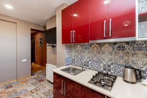 uma cozinha com armários vermelhos e um lavatório em Apartment on Borbalo 16 em Tbilisi