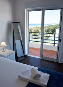 um quarto com uma cama e vista para o oceano em Beach House em Monte Gordo