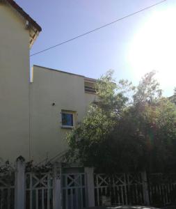 a white house with a fence and a tree at Logement calme et ensoleillé dans maison de ville in Villejuif