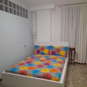 a bedroom with a bed with a floral comforter at Veneziacentopercento Apartments & Rooms in Venice