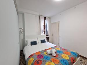 ein Schlafzimmer mit einem großen Bett mit einer bunten Decke in der Unterkunft Veneziacentopercento Apartments & Rooms in Venedig