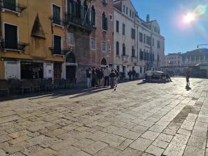 Un groupe de personnes marchant dans une rue dans l'établissement Veneziacentopercento Apartments & Rooms, à Venise