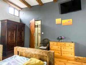 ein Schlafzimmer mit einem Bett, einer Kommode und einem TV in der Unterkunft Stajnia na Warszawskiej in Głubczyce