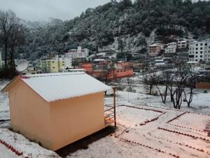 BhowāliにあるNainital Cottage And Resortの雪の積もる小さな建物