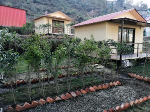 BhowāliにあるNainital Cottage And Resortの木の並ぶ家