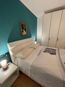 sypialnia z białym łóżkiem i niebieską ścianą w obiekcie Garden Love Venice w Mestre