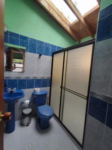 y baño con aseo azul y lavamanos. en Hostal La Pola, en Santa Fe de Antioquia