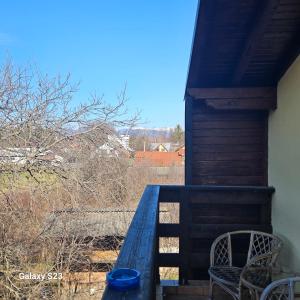 a porch with two chairs and a blue bowl on it at Vila Ralf in Cornu de Jos