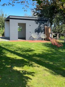 韦斯特雷费尔Hof Steinhütten Boutique Apartments的一座小建筑,在院子里放两把椅子