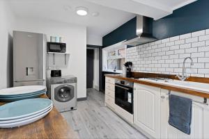uma cozinha com um lavatório e uma máquina de lavar roupa em Sally’s Cottage - Uttoxeter: Close to Alton Towers em Uttoxeter