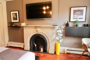 a living room with a fireplace with a tv above it at The West Village Gem in New York