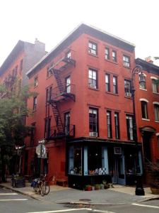 un grand bâtiment en briques rouges dans une rue de la ville dans l'établissement The West Village Gem, à New York