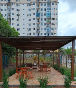 um pátio com mesas e cadeiras e um grande edifício em House praia em São José de Ribamar