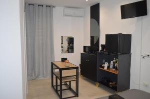 uma sala de estar com uma pequena mesa e uma televisão em Geometric Art Home em Bari