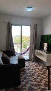 uma sala de estar com um sofá e uma grande janela em House praia em São José de Ribamar