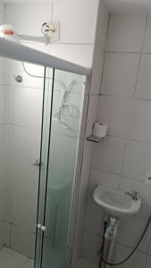 uma casa de banho com um lavatório e uma cabina de duche em vidro. em House praia em São José de Ribamar
