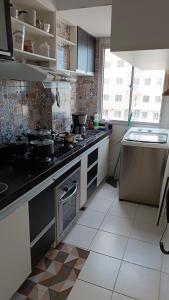 a kitchen with a stove with pots and pans on it at House praia in São José de Ribamar