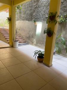 a patio with potted plants and a yellow column at Residencial Morro de São Paulo in Morro de São Paulo