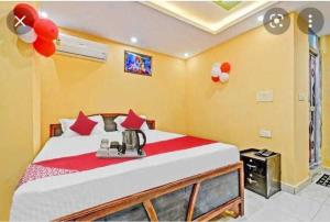 a bedroom with a large bed with red pillows at OYO Hotel Swarna Palace in Patna