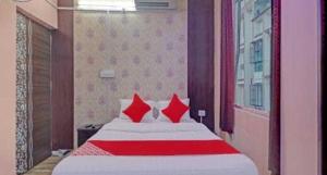 a bedroom with a large bed with red pillows at OYO Hotel Swarna Palace in Patna