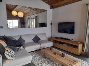 sala de estar con sofá y TV de pantalla plana en Marmotte 205 - Splendide duplex aux pieds des pistes en Bonneval-sur-Arc