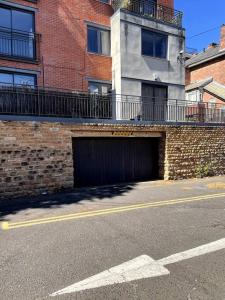 a brick building with a garage on the side of a street at Lovely 2 bedroom flat with free parking Flat 5 in Nottingham