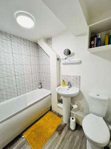 a bathroom with a sink and a toilet and a bath tub at Lovely 2 bedroom flat with free parking Flat 5 in Nottingham