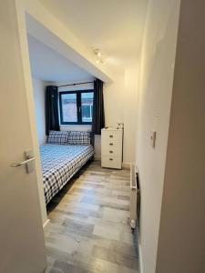 Habitación pequeña con cama y ventana en Lovely 2 bedroom flat with free parking Flat 5, en Nottingham