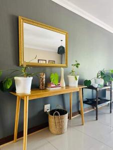 a mirror on a wooden table with plants on it at 21 at Melody in Hartbeespoort