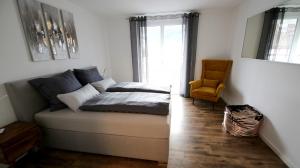 ein Schlafzimmer mit einem Sofa, einem Stuhl und einem Fenster in der Unterkunft Purer Genuss - 110qm in Owingen