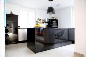eine Küche mit schwarzen Schränken und einer schwarzen Arbeitsplatte in der Unterkunft Purer Genuss - 110qm in Owingen