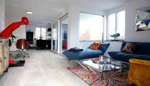 een woonkamer met blauwe banken en een glazen tafel bij Purer Genuss - 110qm in Owingen