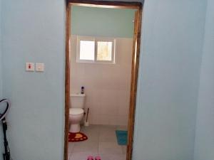 een badkamer met een toilet, een raam en een deuropening bij JM ACCOMMODATIONs in Watamu