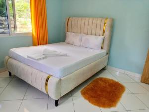 een bed in een kamer met een tapijt bij JM ACCOMMODATIONs in Watamu