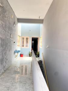 a hallway with white walls and a staircase in a building at PP White Town Rooms in Puducherry