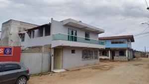 uma casa branca ao lado de uma estrada de terra em Apto em Marataízes-ES, 03 quartos e 02 banheiros em Marataízes