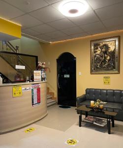 a waiting room with a leather couch and a table at Wency Amor Hotel in Sablayan