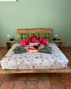 un lit avec des ballons rouges en haut dans l'établissement Il Bosco Incantato, à Borgo San Dalmazzo